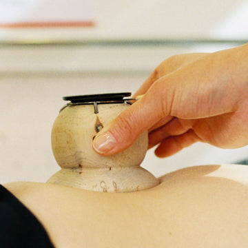 A Tong-in clinic doctor performing moxibustion treatment on the patient's abdomen.